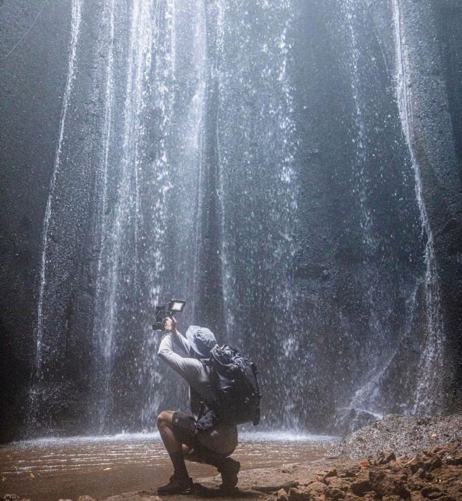 Picture of pro photographer taking a picure of a waterfall wearing a shelta sun hat