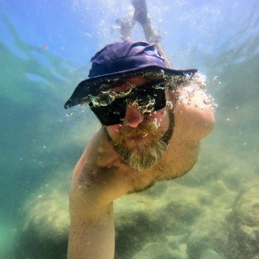 Picture of man under water wearing a shelta sun hat