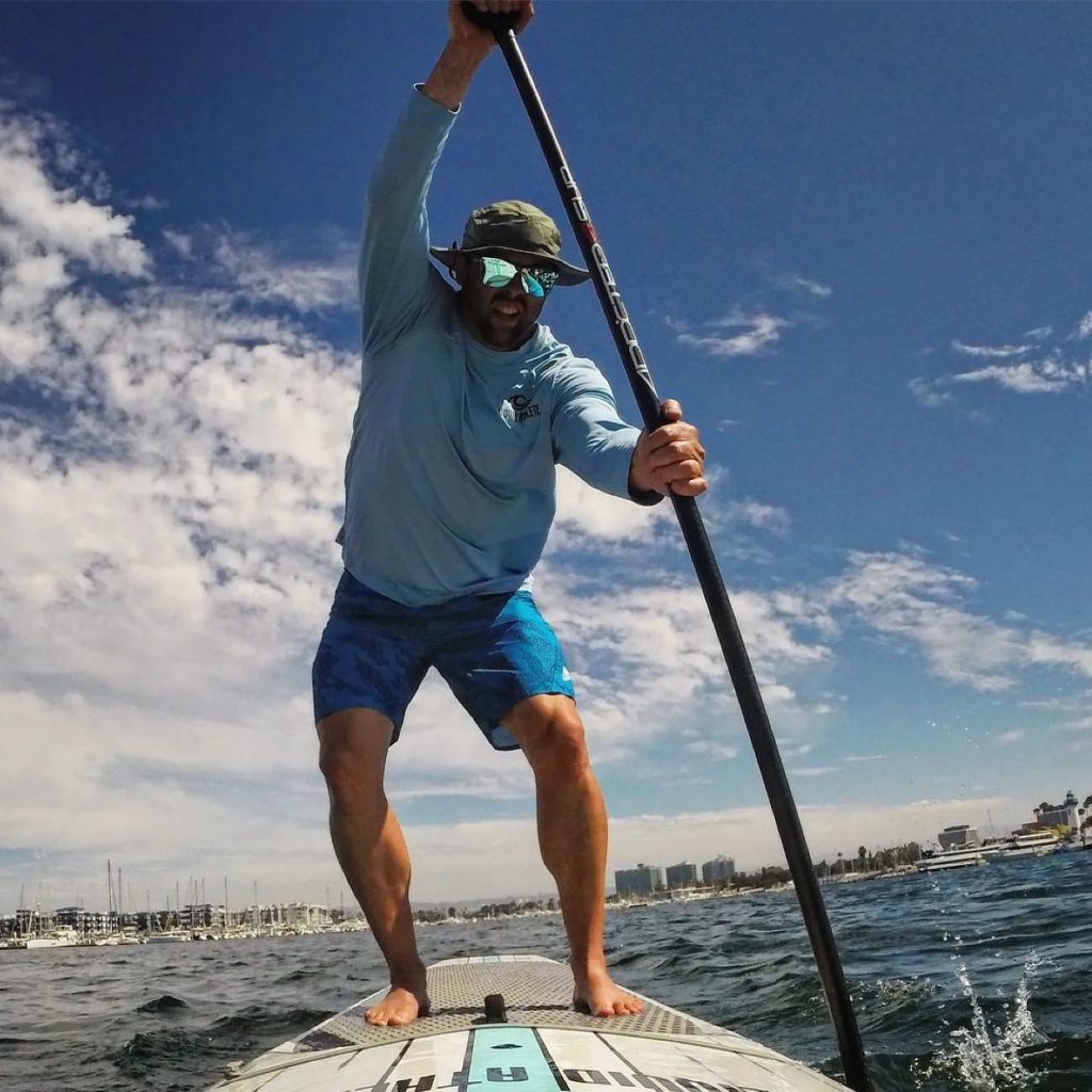 Picture of a paddle boarder paddling with a Shelta Seahawk Sun Hat