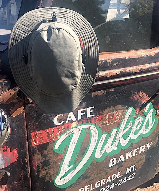 Picture of the Land Hawk sun hat over a cafe dukes bakery sign in Montana