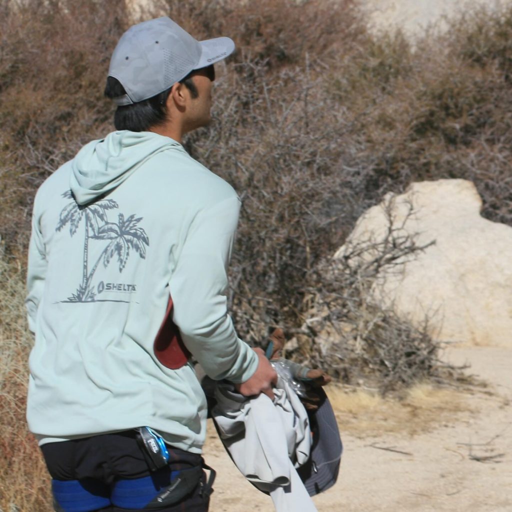 Picture of man wearing a shelta cap on shirt in the desert