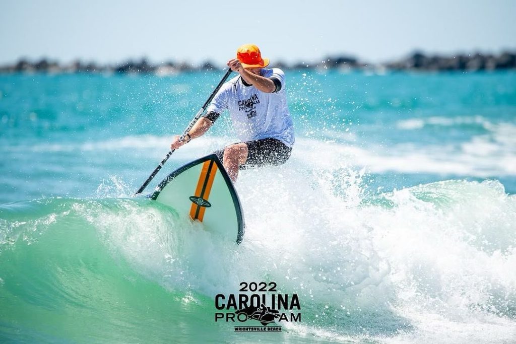 Stand Up Paddle surfer boucing off the lip wearing an orange shelta sun hat